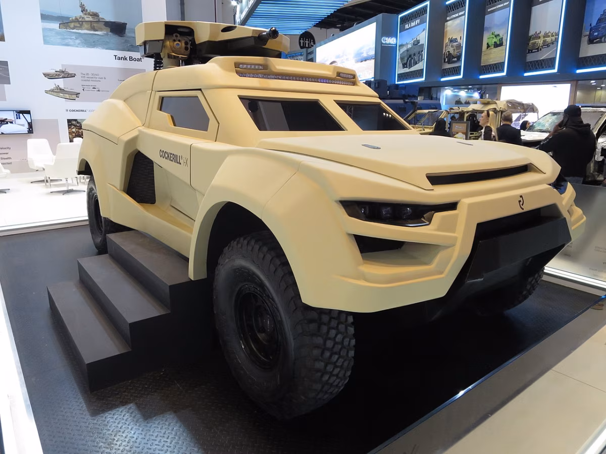 Cockerill i-X 4x4 ground interceptor on display at IDEX 2023, turret deployed, showing its low-profile rally-derived body in desert tan