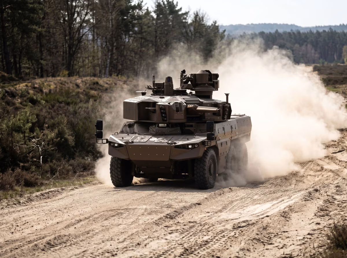 KNDS JAGUAR EBRC on a dirt track during trials, showing the 6x6 wheeled chassis and T40 turret kicking up dust at speed