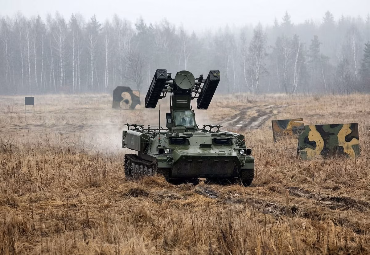 9A34 combat vehicle of the Strela-10 system in the field, with four missile canisters raised and the Snap Shot ranging radar dish visible between the launcher arms