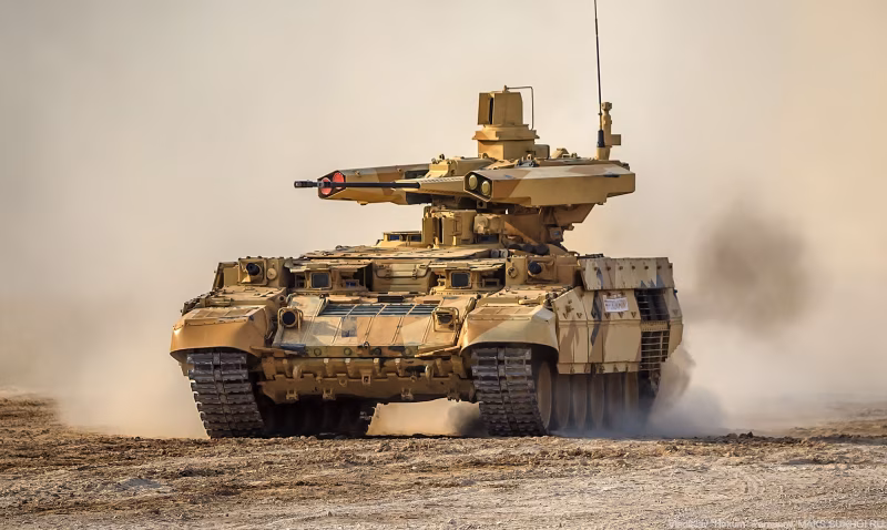 BMPT Terminator driving through a Moscow street during a Victory Day parade rehearsal, with two crew members visible and the twin 30mm autocannons elevated.