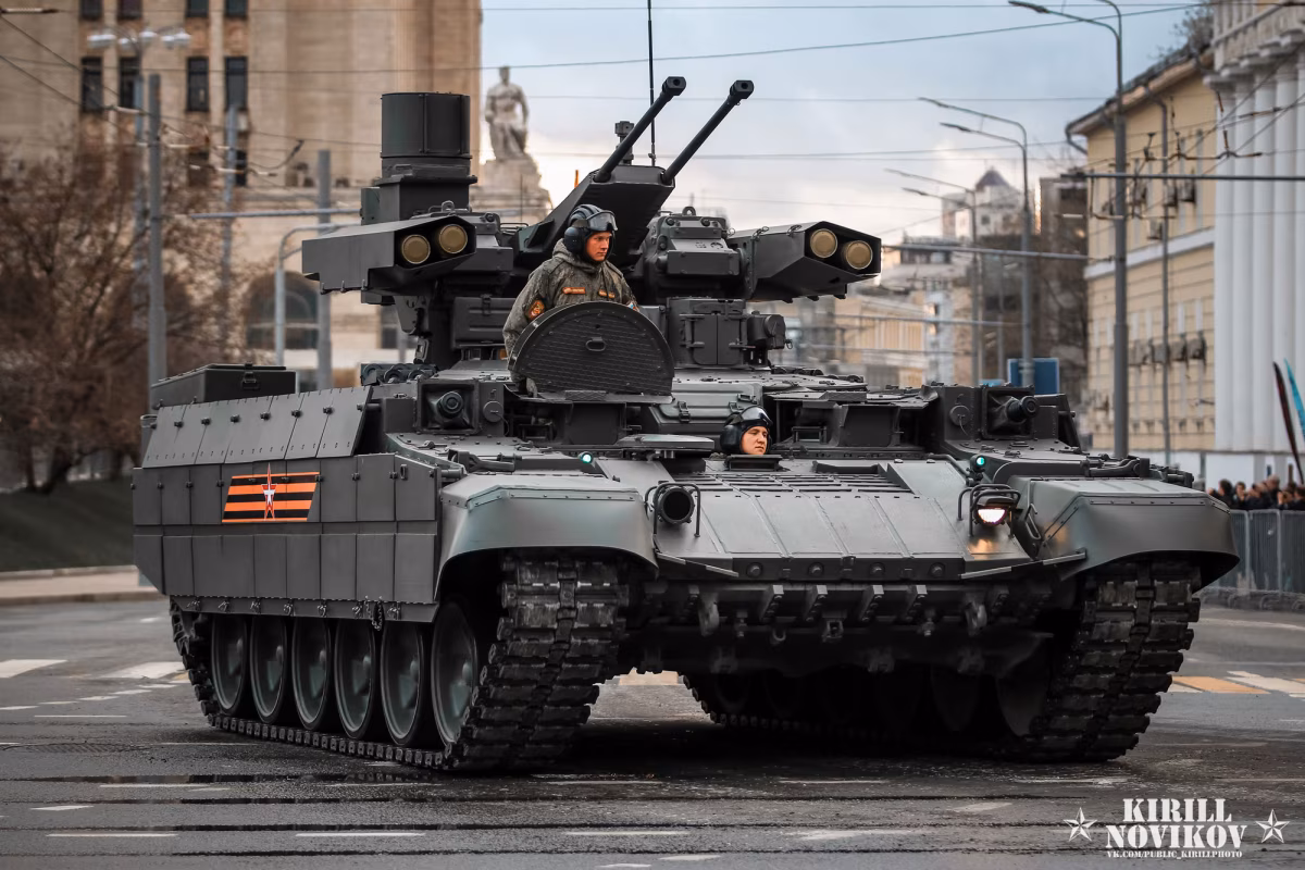 BMPT Terminator during a Moscow Victory Day parade rehearsal, seen head-on with the commander standing in the hatch, twin 30mm autocannons and Ataka missile launchers clearly visible on the unmanned turret.