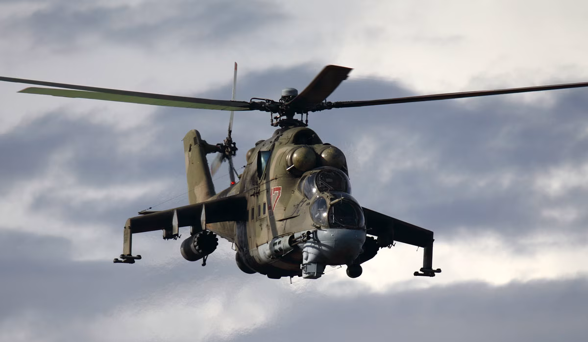 Russian Air Force Mil Mi-24P Hind attack helicopter in flight, viewed head-on against an overcast sky.
