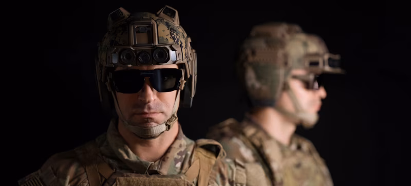 Two soldiers wearing Anduril EagleEye helmet system with AR display glasses and sensor-mounted tactical helmets